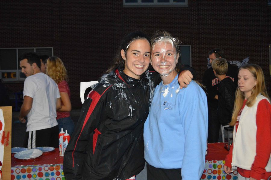 Junior Jen OConnor and  senior Abbie Houck pose after getting pied at Class Officer Homecoming carnival booth. 