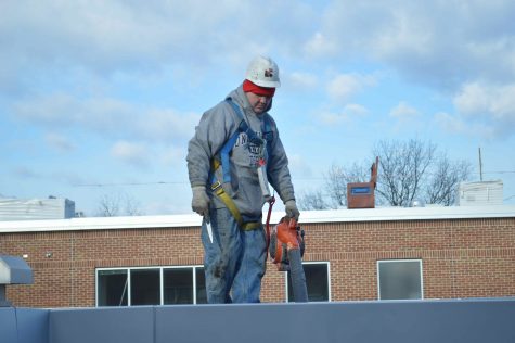 A worker stands on the roof outside the 800s hallway as construction continues at BASH.