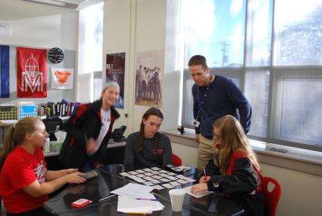 Mr. Peterson discusses math problems with students.