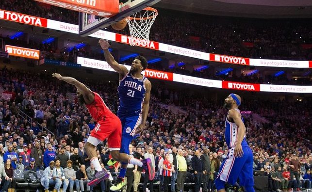 Sixers Joel Embiid viciously blocks Rockets James Harden as Sixers Corey Brewer looks on.