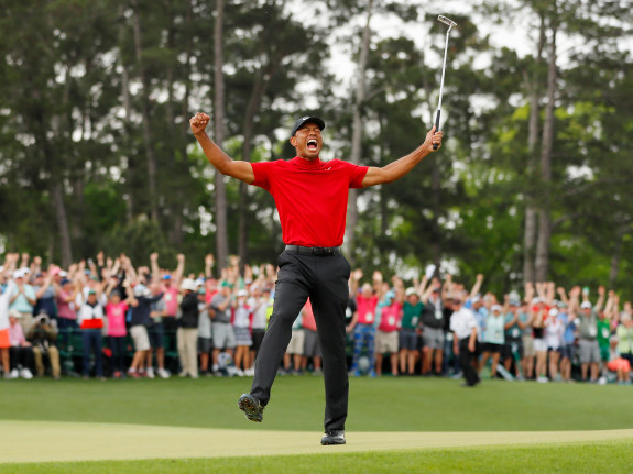 Tiger Woods of the United celebrates after sinking his putt on the 18th green to win.