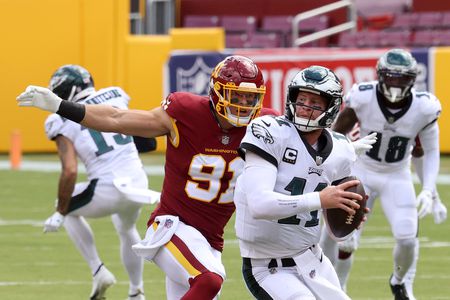 Ryan Kerrigan closes in on Carson Wentz, to sack him.