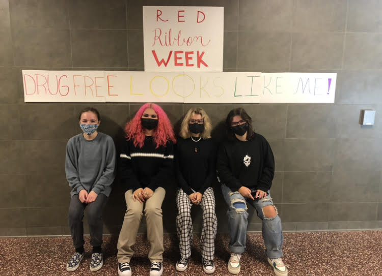 SADD+club+members+posing+in+front+of+the+Red+Ribbon+Week+sign.