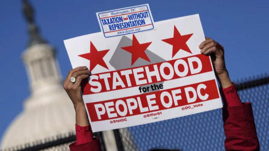 D.C resident showing her support for D.C statehood by holding up a pro-statehood sign.
