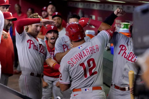 Phillies player Kyle Schwarber (12) being greeted in the dugout by his teammates after hitting a three run home run against the Arizona Diamondbacks during the fourth inning of a baseball game.