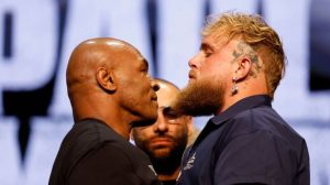 Mike Tyson (left) and Jake Paul (right) standing face-to-face in a standoff