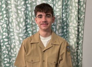 Yeshaya standing in his NJROTC uniform in his living room. 